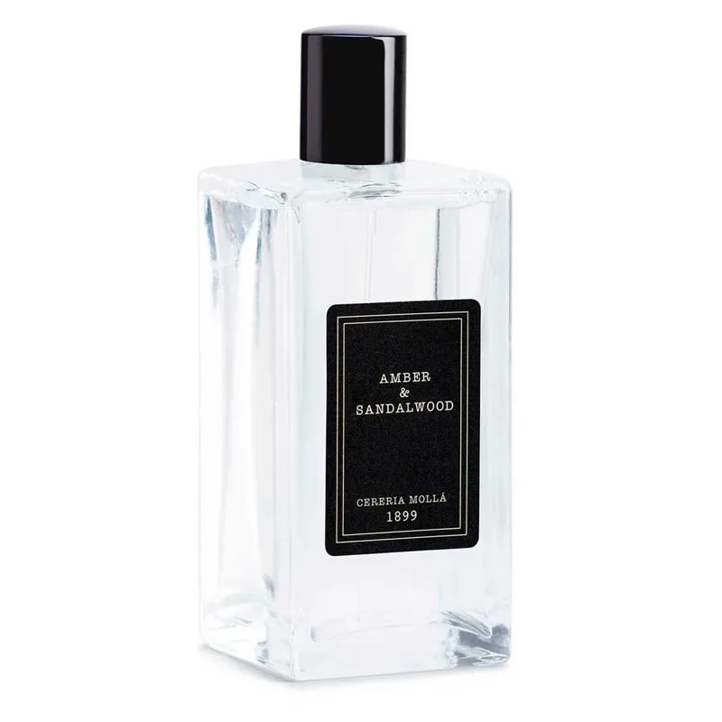 Angled view of the clear Amber and Sandalwood bottle with black cap and gold-bordered black label