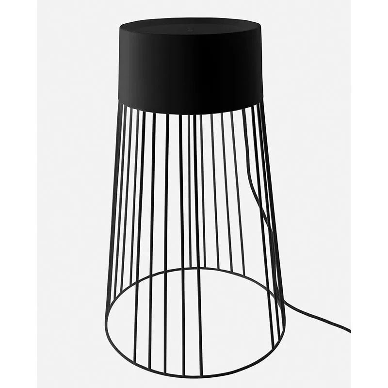 Koster black metal floor lamp with a conical wire cage base and solid top, front view on white