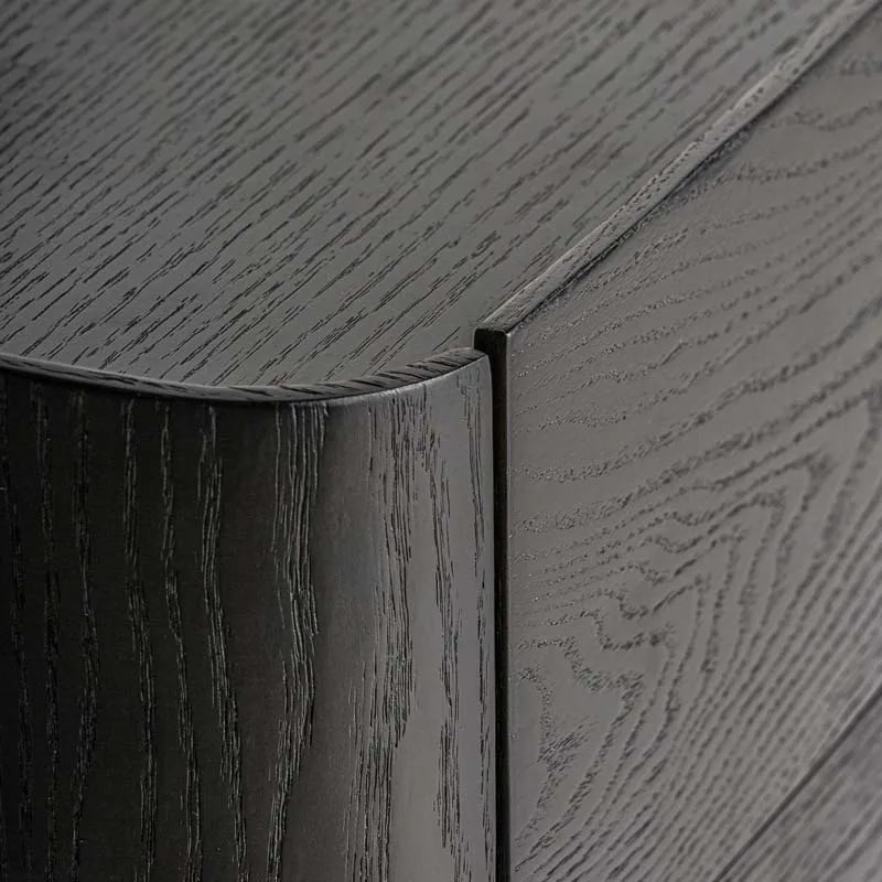 Close-up of the rounded corner and drawer gap on the Wolfach black oak bedside table