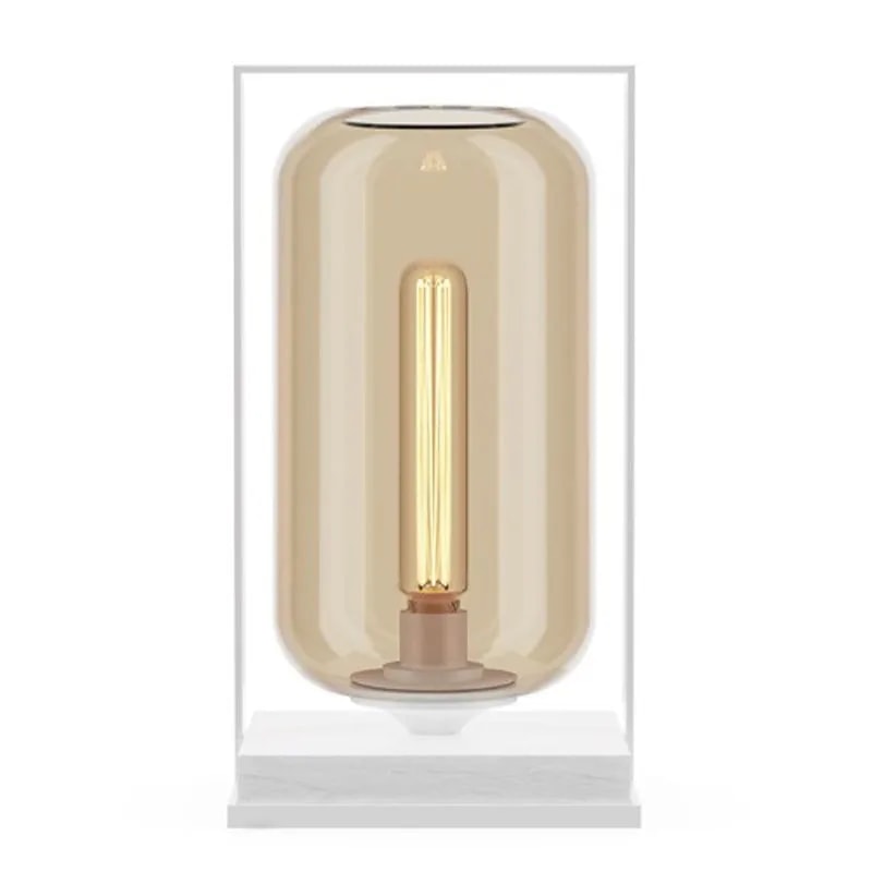 Tube Wood 40 table lamp with an amber glass tube shade in a white frame on a white marble base, filament glowing