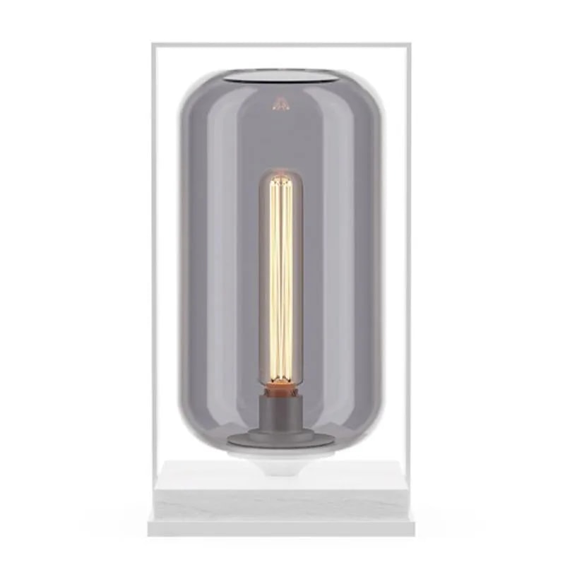 Tube Wood 40 table lamp with a smoke grey glass tube shade in a white frame on a white base, warm bulb inside