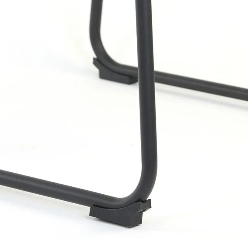 Close-up of the black sled legs and footrest bar with floor caps on the JEDDO boucle bar chair
