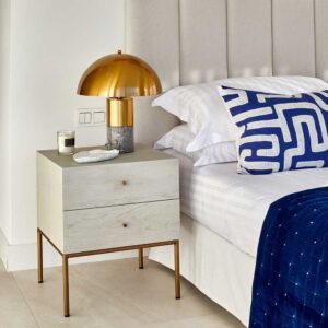 Mesita de noche en roble blanco grisáceo patinado con patas metálicas en dorado envejecido